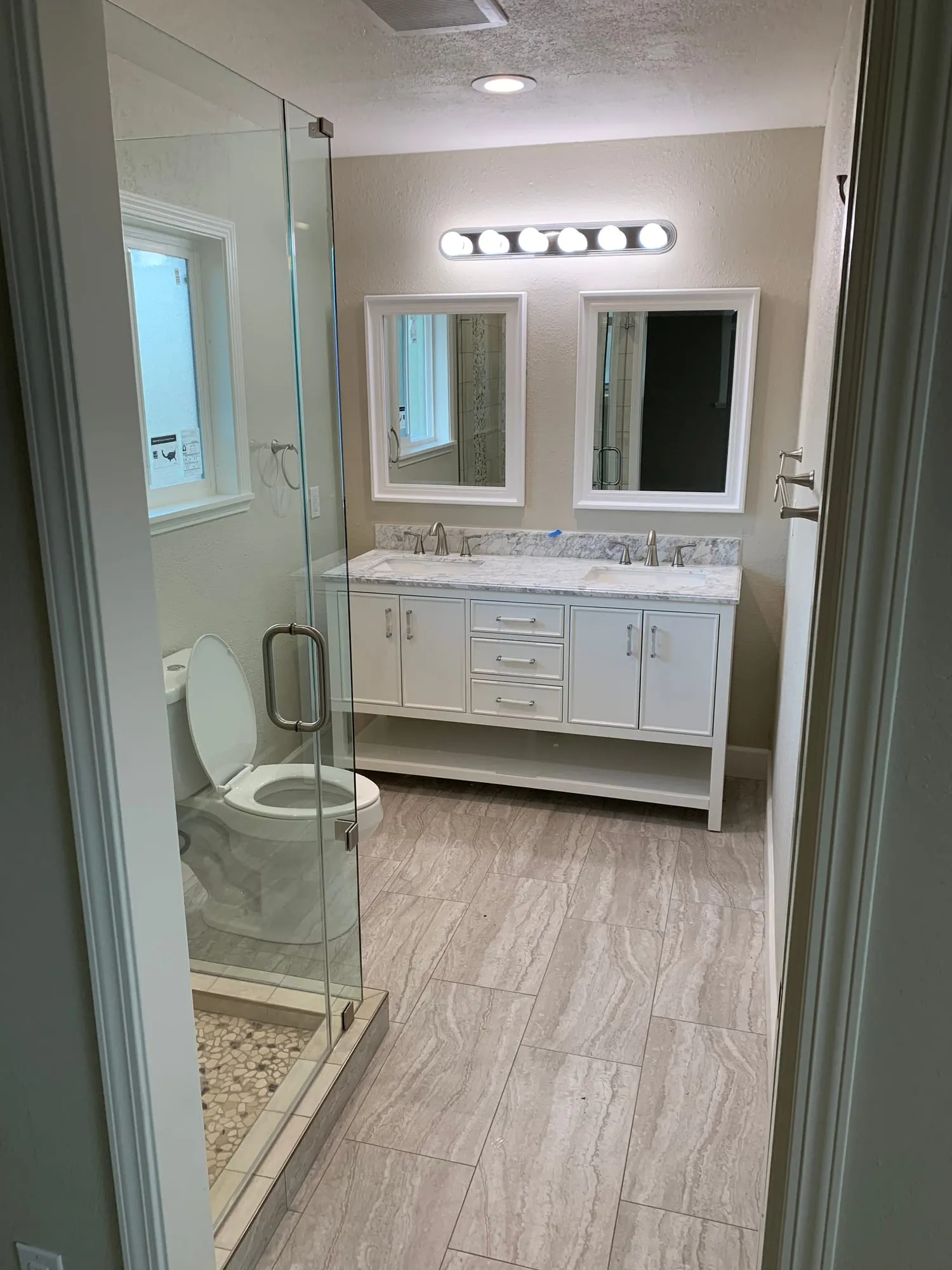 Pebble-Floor Shower & Double Vanities by PrimeSpec Construction — photo 1 of 5