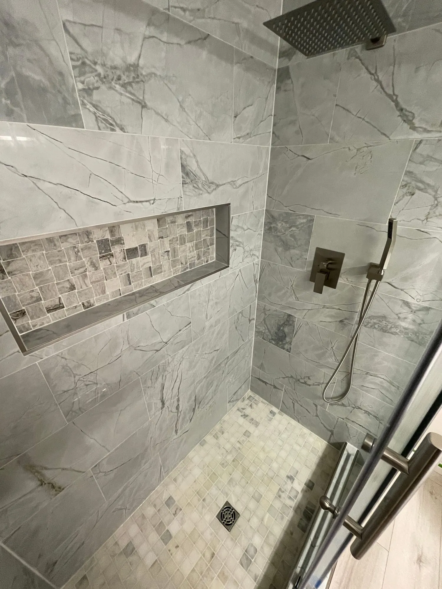 Marble-Look Shower with Mosaic Niche by PrimeSpec Construction — photo 1 of 2