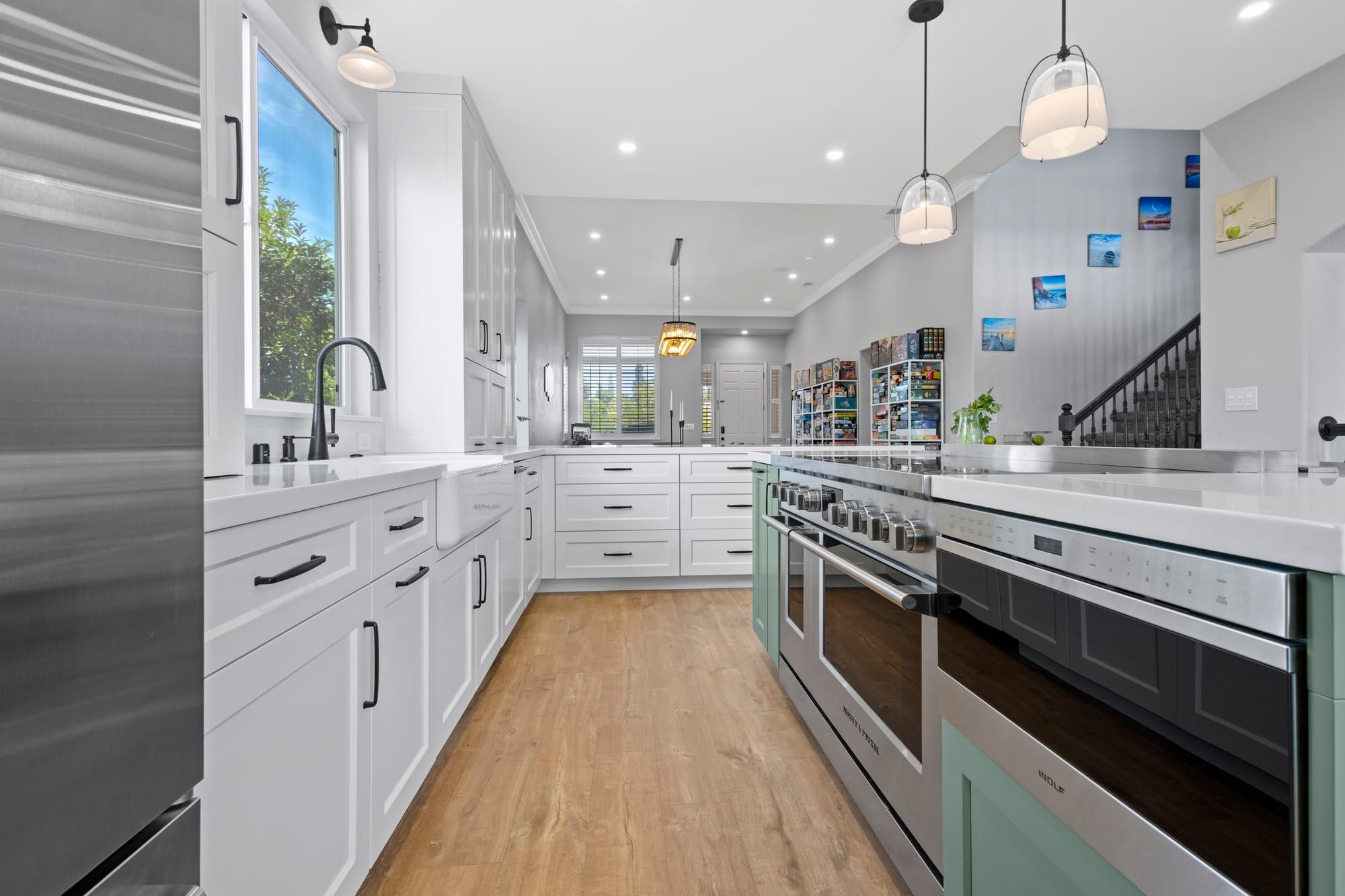 Remodeled kitchen with white cabinets and sage island