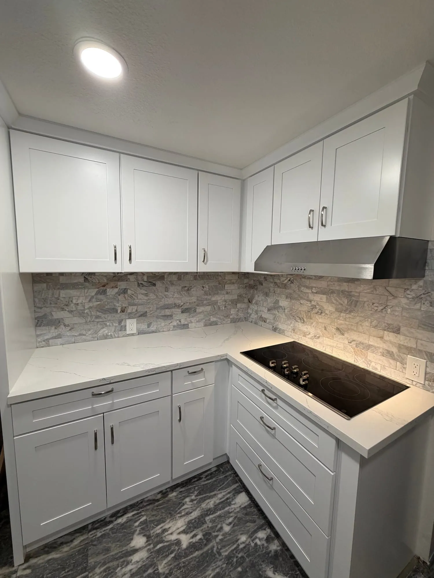 White Kitchen with Stacked-Stone Backsplash by PrimeSpec Construction — photo 1 of 2