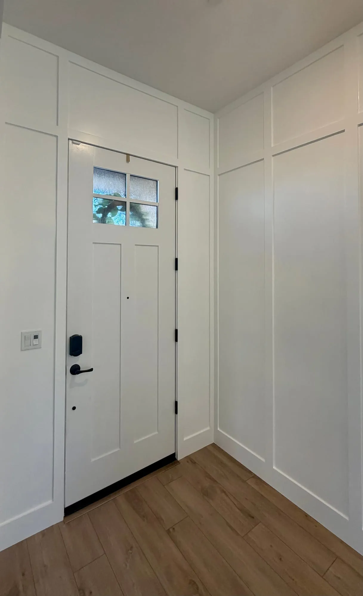 Entryway with full-height white board and batten paneling